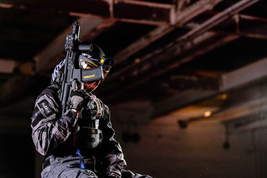 Masked player with KWA rifle in a warehouse arena
